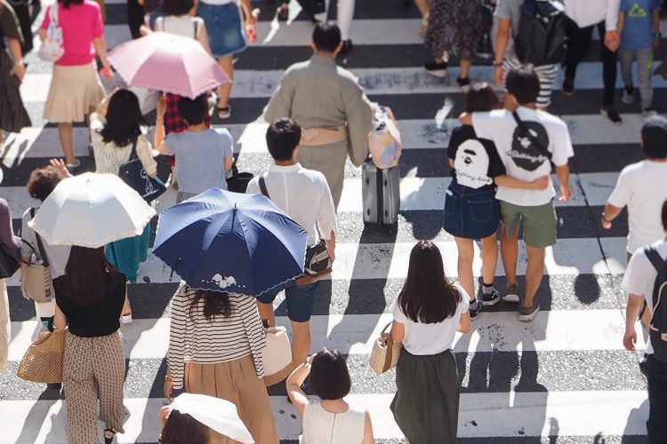 横断歩道など混雑している場所では日傘に当たらないよう注意したい（イメージ）