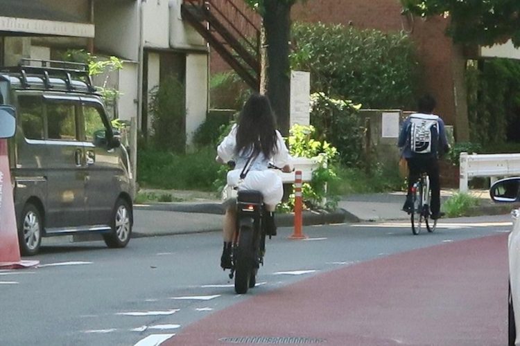 ノーヘル・ナンバープレートなしで車道を走るモペッド（疋田智氏提供）