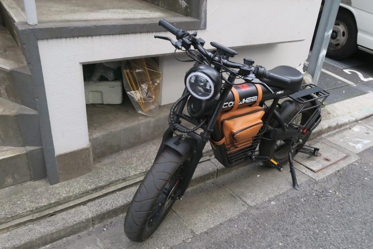 路上に駐輪されたモペッド。一見オートバイのようだが、よく見ると自転車のペダルのようなものが付いている（疋田智氏提供）