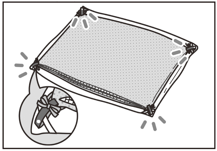 広げた布団の上に裏返した布団カバーを重ね、四隅にネームタグを通して固定。付属のリボンはネームタグに結ぶ