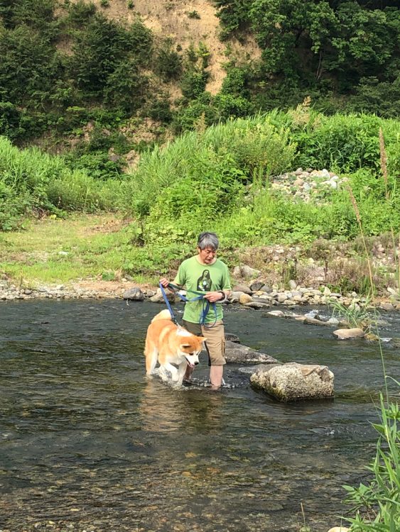 夫の豊さんと愛犬のつぶ（秋田犬）。散歩ルートには美しい川が。東京ではありえない日常