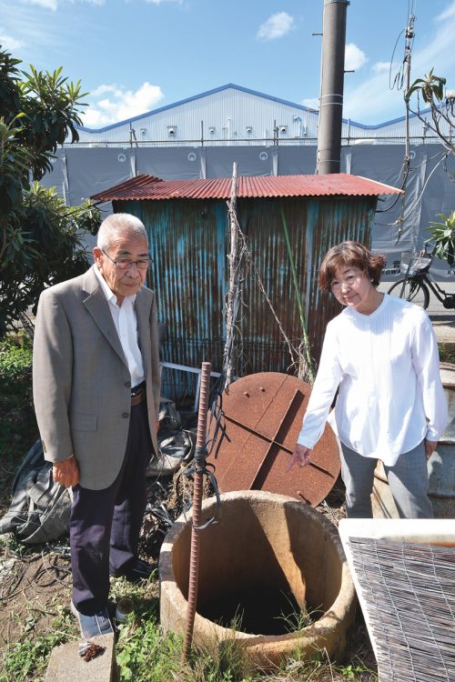 3万ng/Lが検出された摂津市・一津屋の井戸はダイキン工業の淀川製作所（写真奥）の至近にある（左から「大阪・摂津市PFOA汚染問題を考える会」代表の清水信行氏と、事務局で摂津市議の増永和起氏）